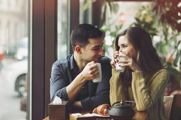 Couple in love drinking coffee and have fun in coffee shop. Love concepts. Vintage effect style picture