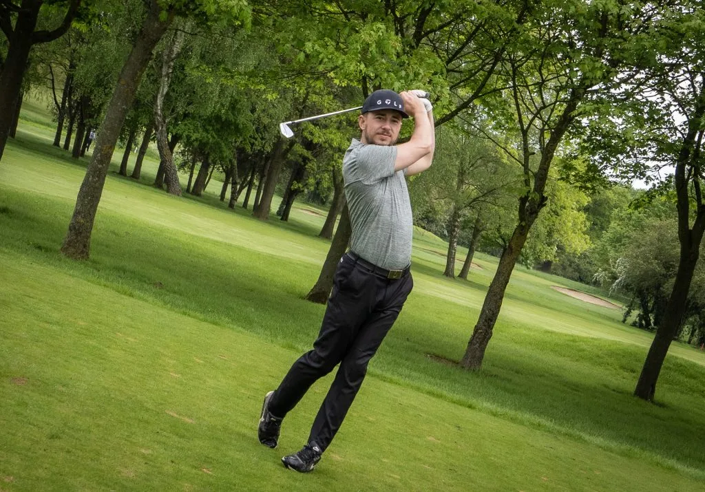 Man hitting a golf ball at a golf club in Milton Keynes