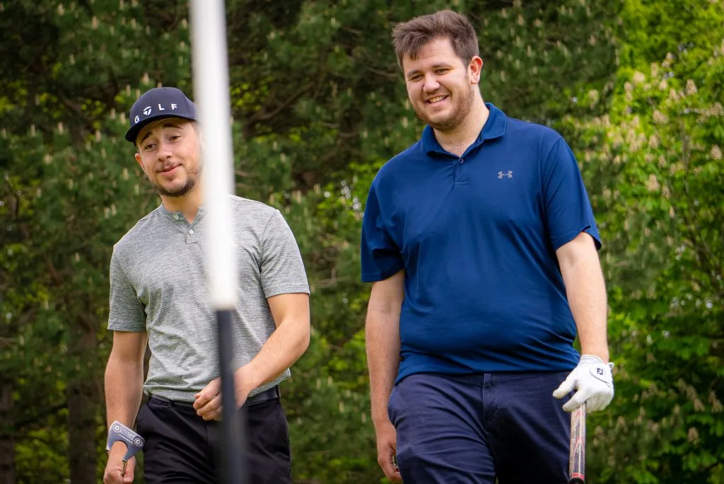 Two golfers walking towards a golf hole on a Milton Keynes golf course