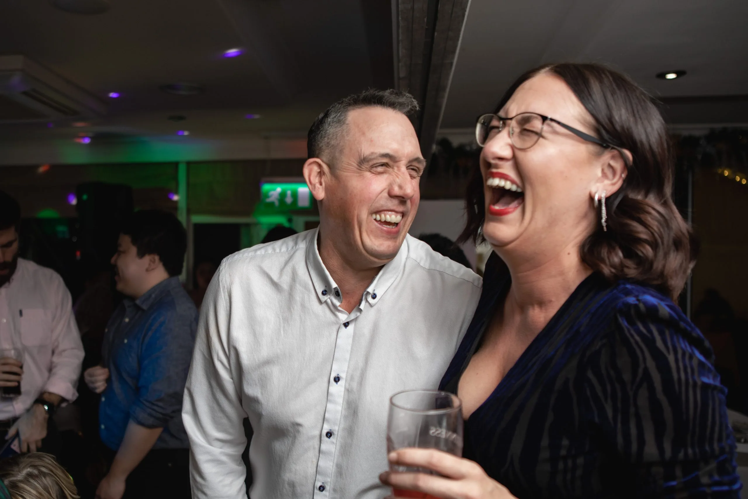 two people hysterically laughing during a party in milton keynes