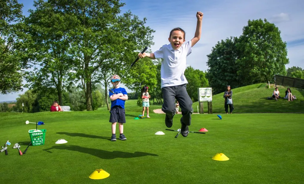 kid jumping during junior golf lesson