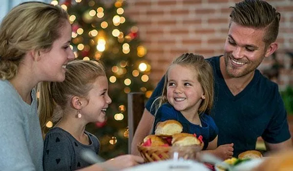 young family smiling and enjoying a christmas lunch in milton keynes