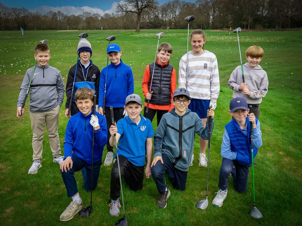 kids kneeling for photo during a junior golf lesson in milton keynes