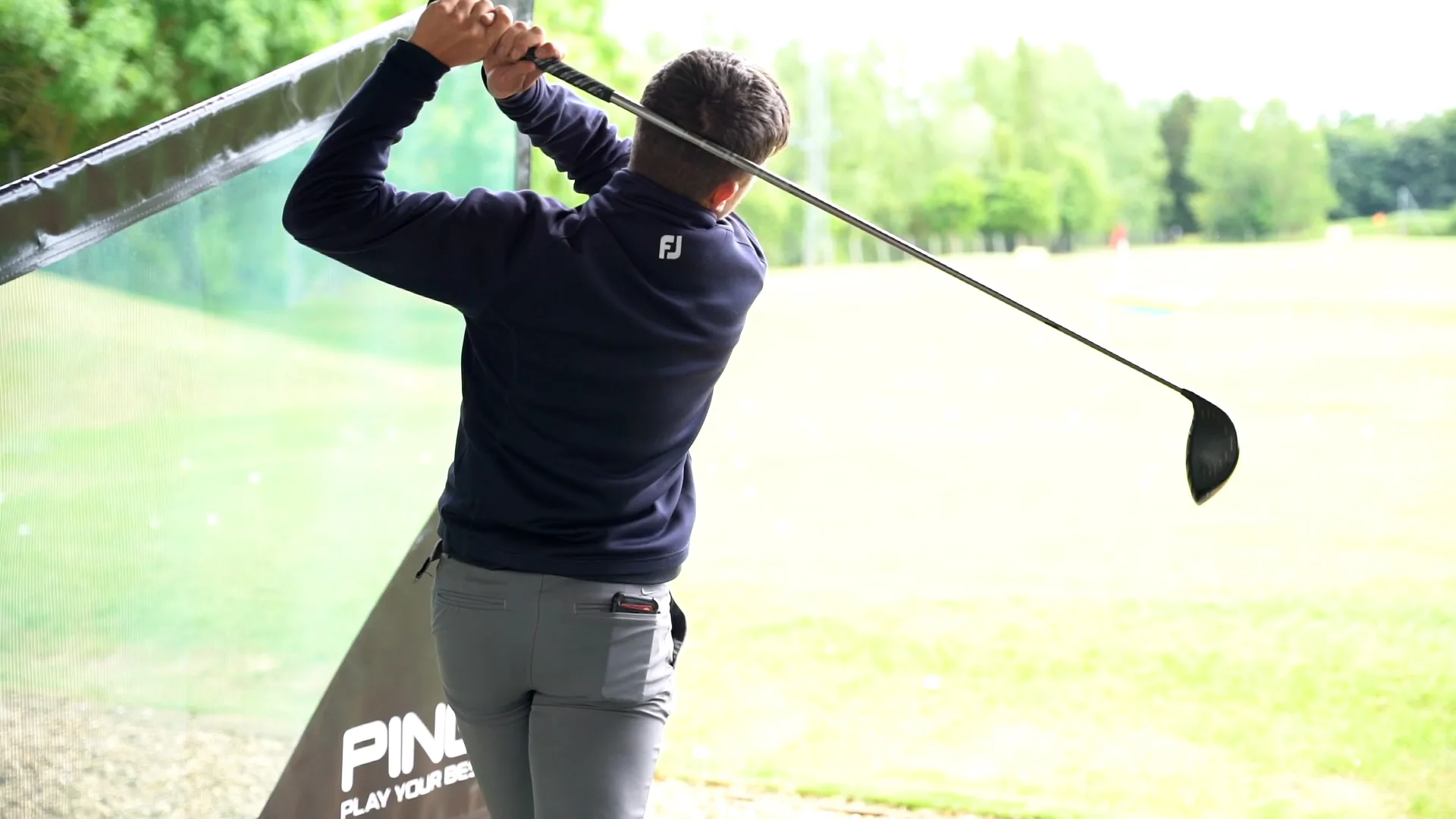 Man hitting a golf ball at a trackman driving range in Milton Keynes