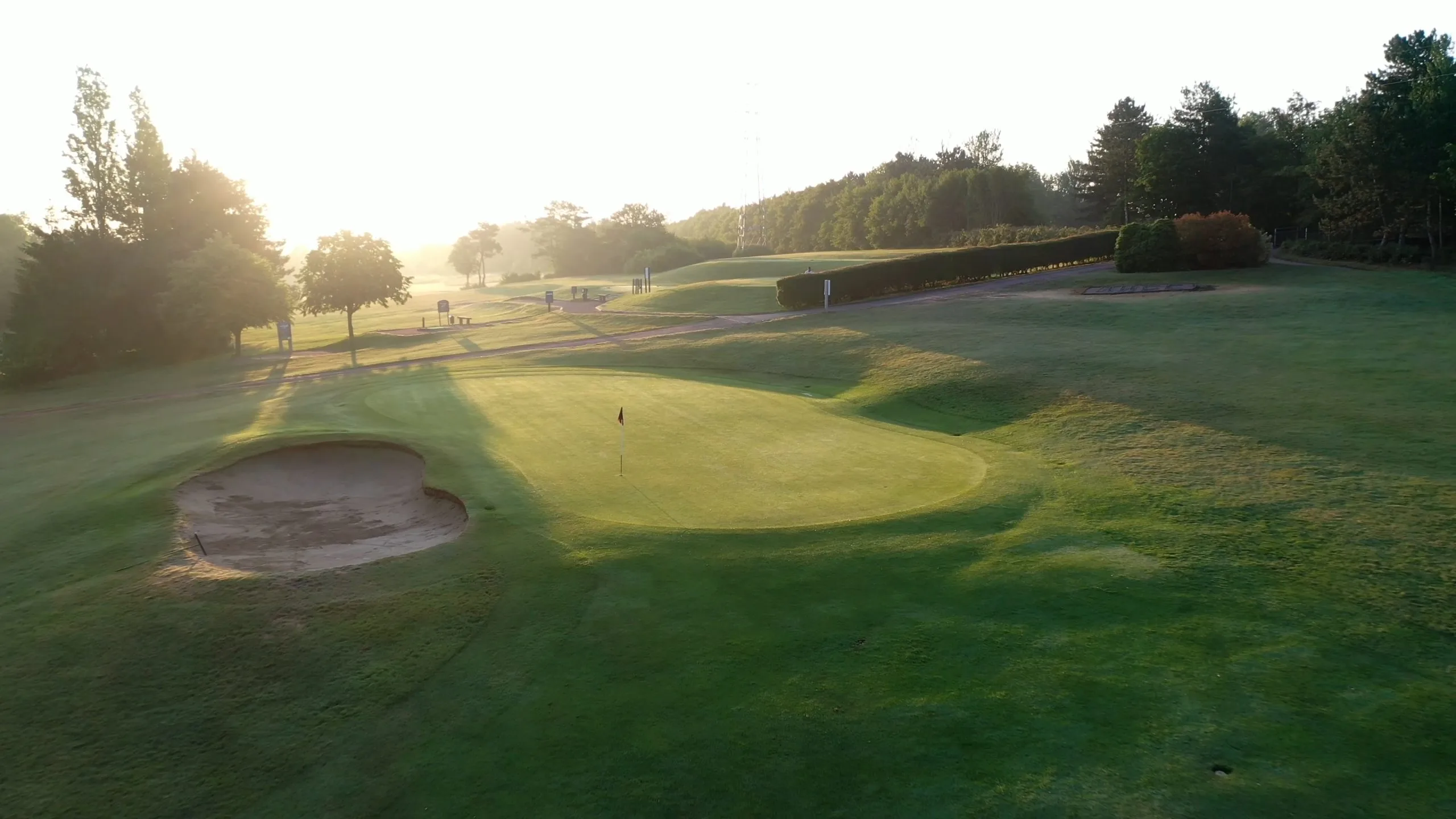 18 hole golf course Milton Keynes, golf green in the morning with the sun rising over the horizon.