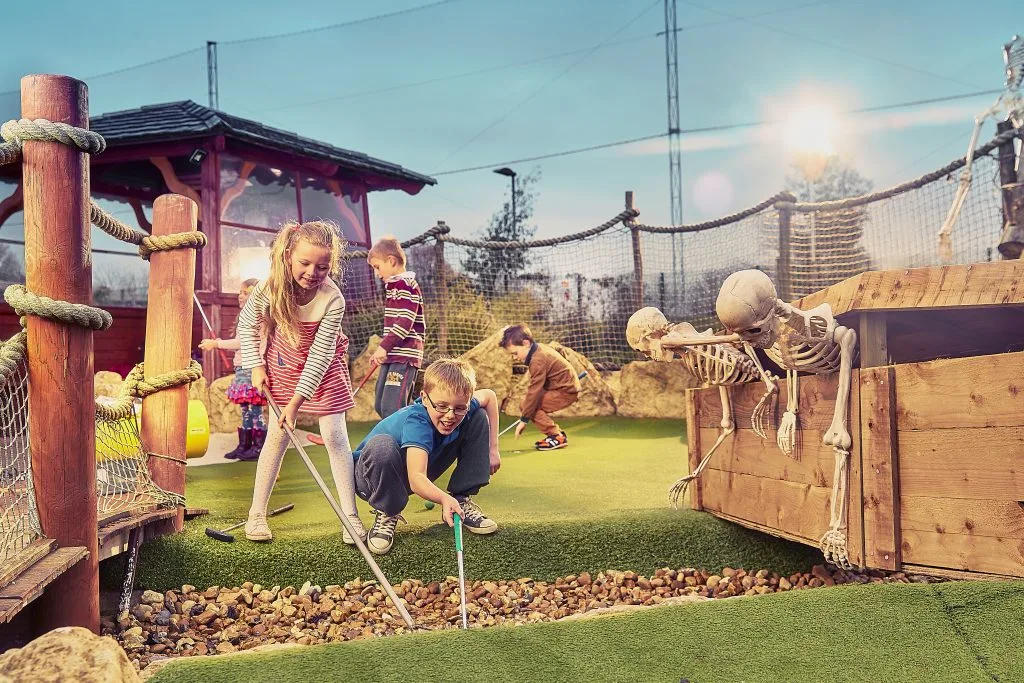 group of kids having fun playing mini golf in milton keynes