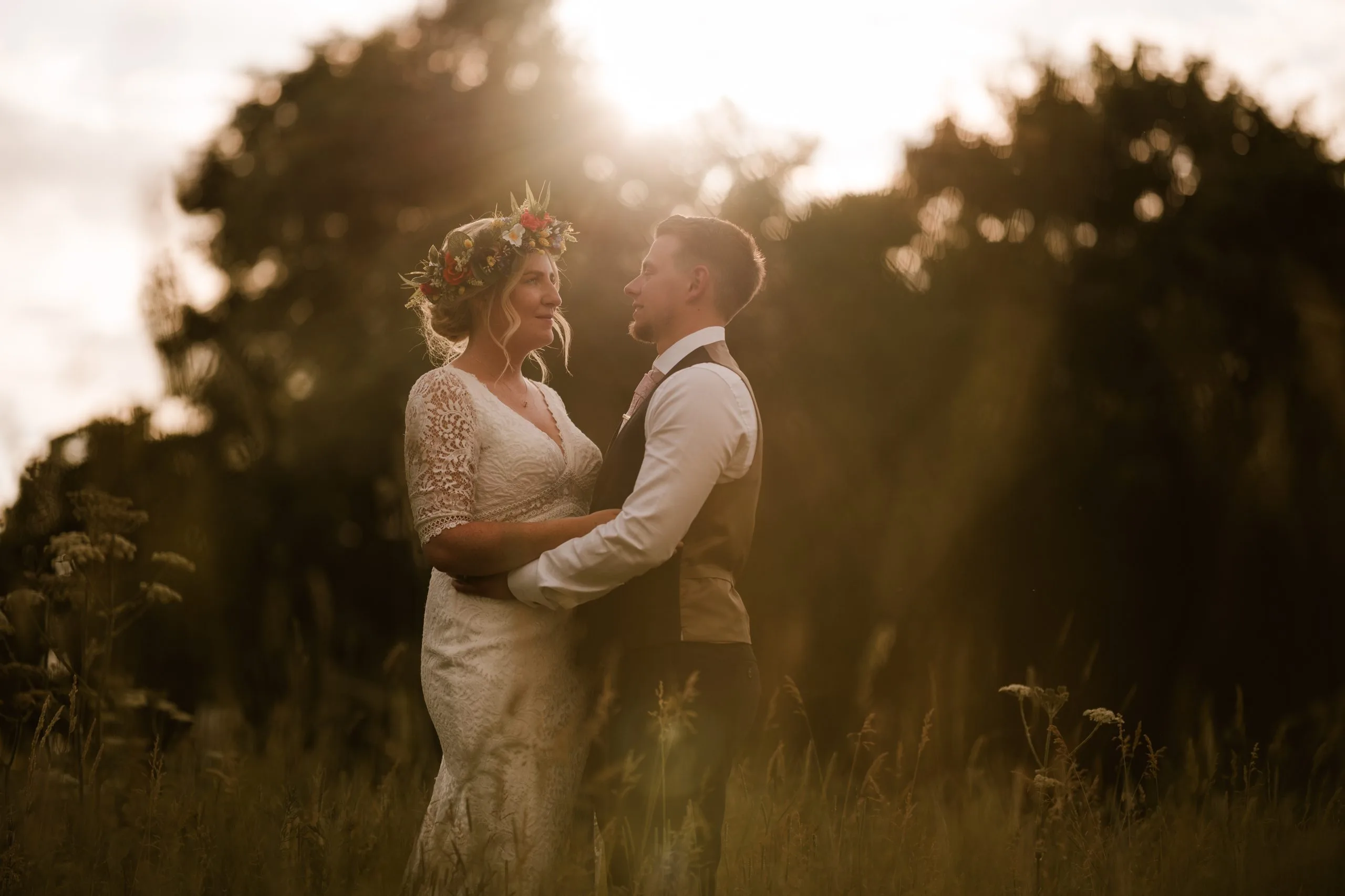 newly married couple kissing with sun in background after a wedding in milton keynes