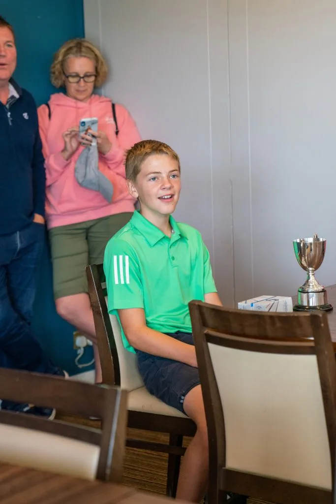 junior golfer with trophy after golf tournament in milton keynes
