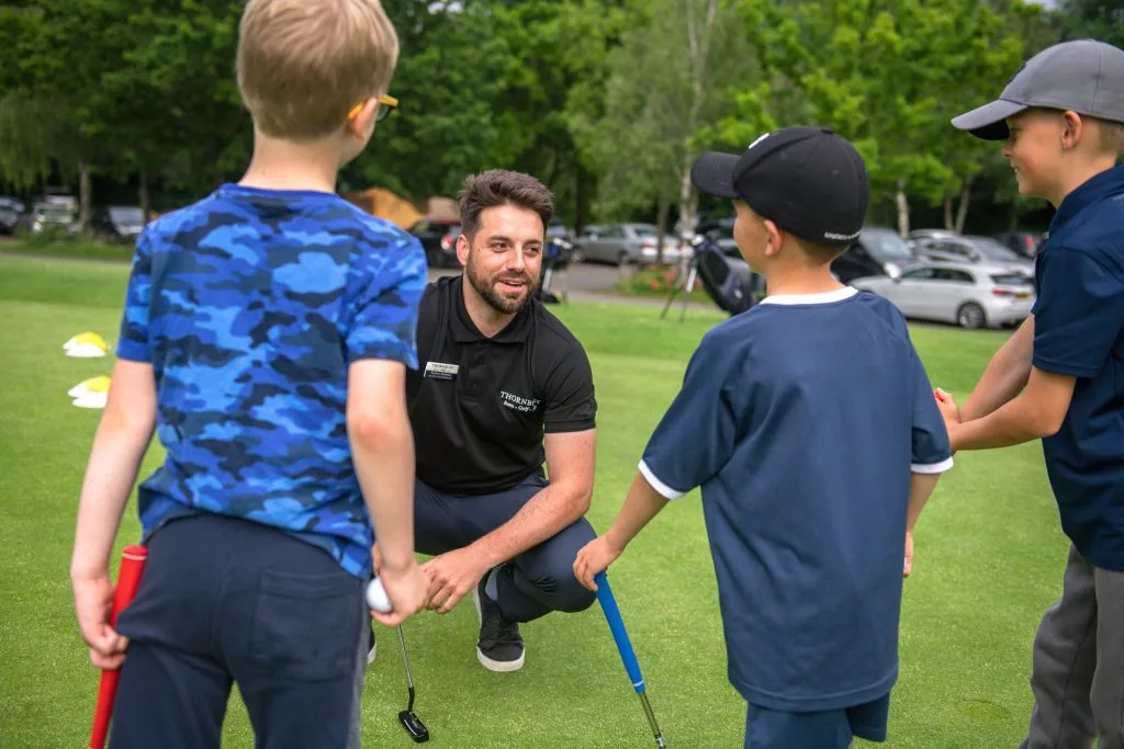 golf coach teaching a junior group golf lesson in milton keynes
