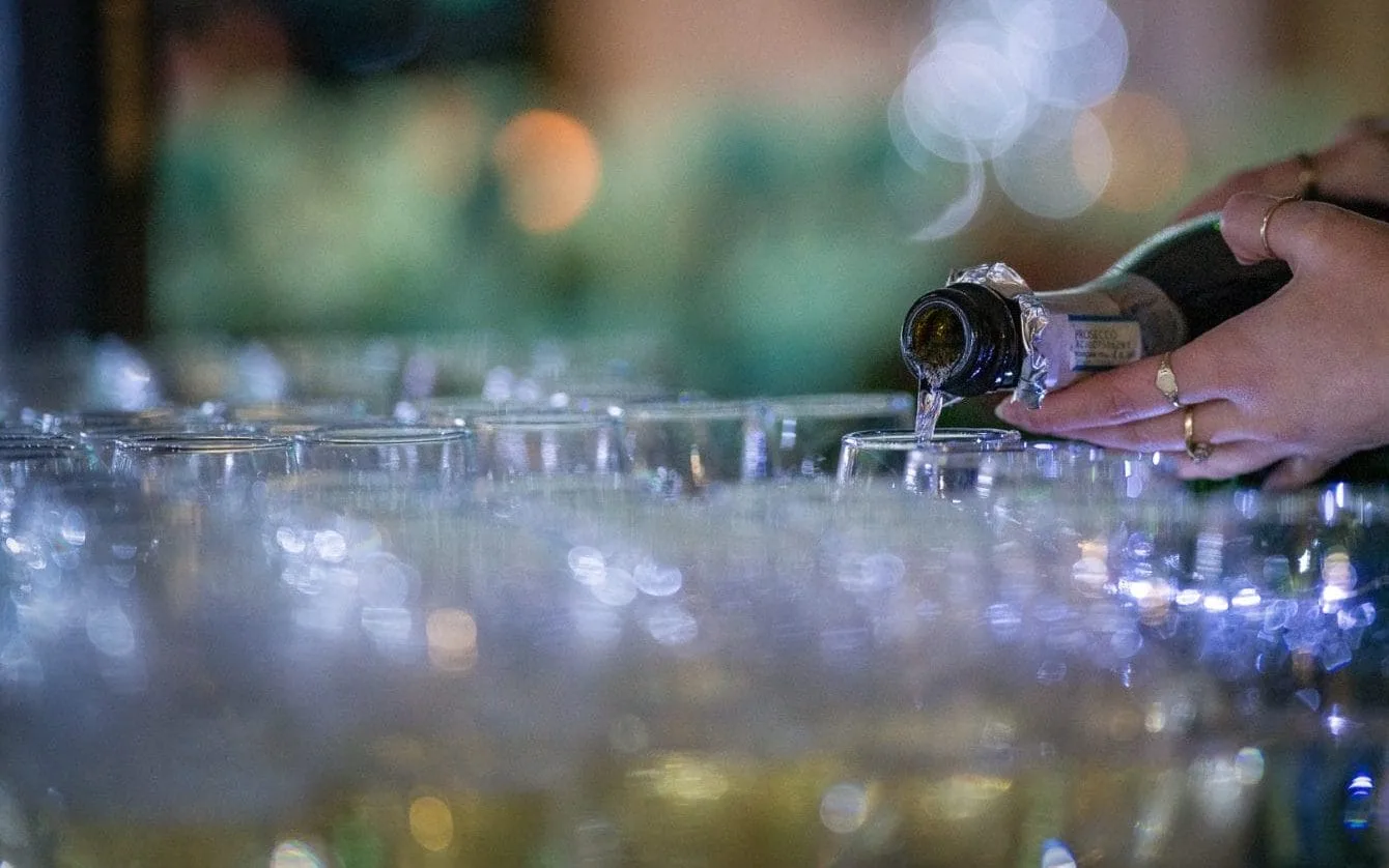 prossecco being poured in a number of glasses at a christmas party venue in milton keynes